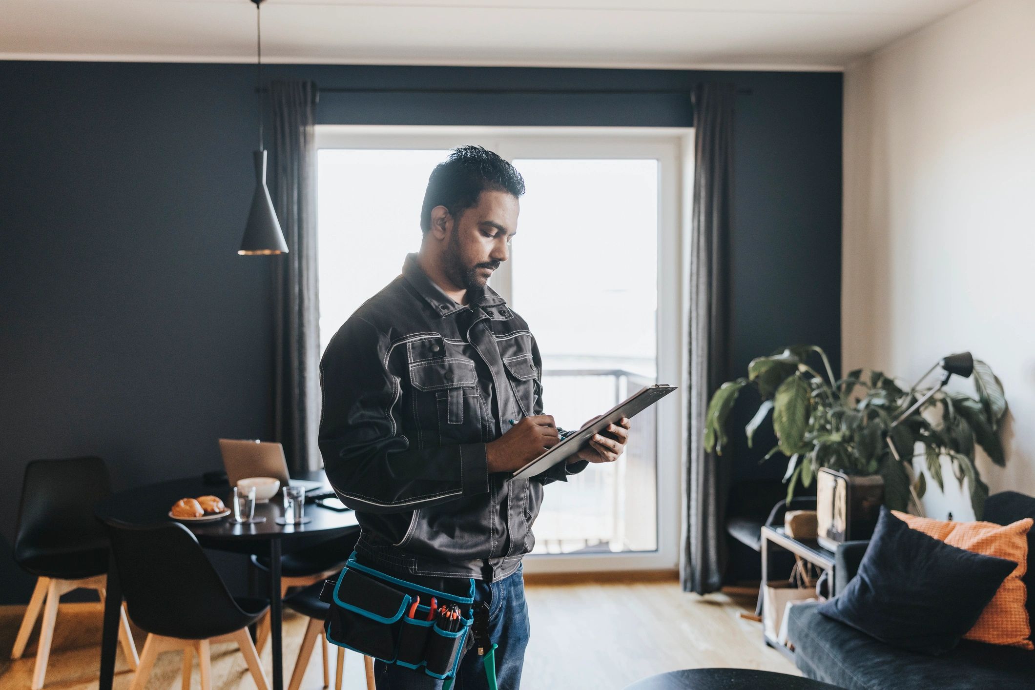 Technician writing list of jobs at customers house