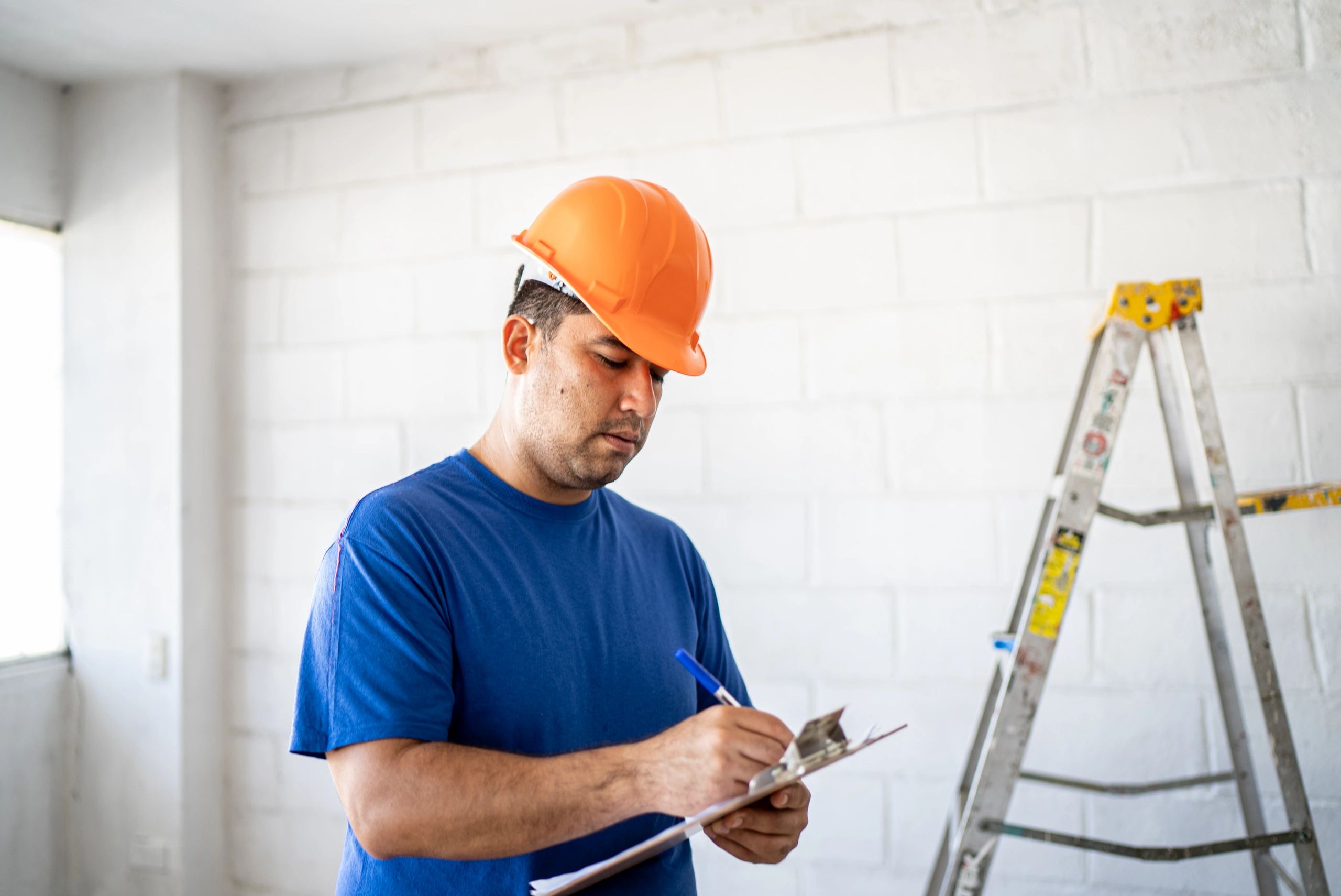 Technician taking notes during a home assessment