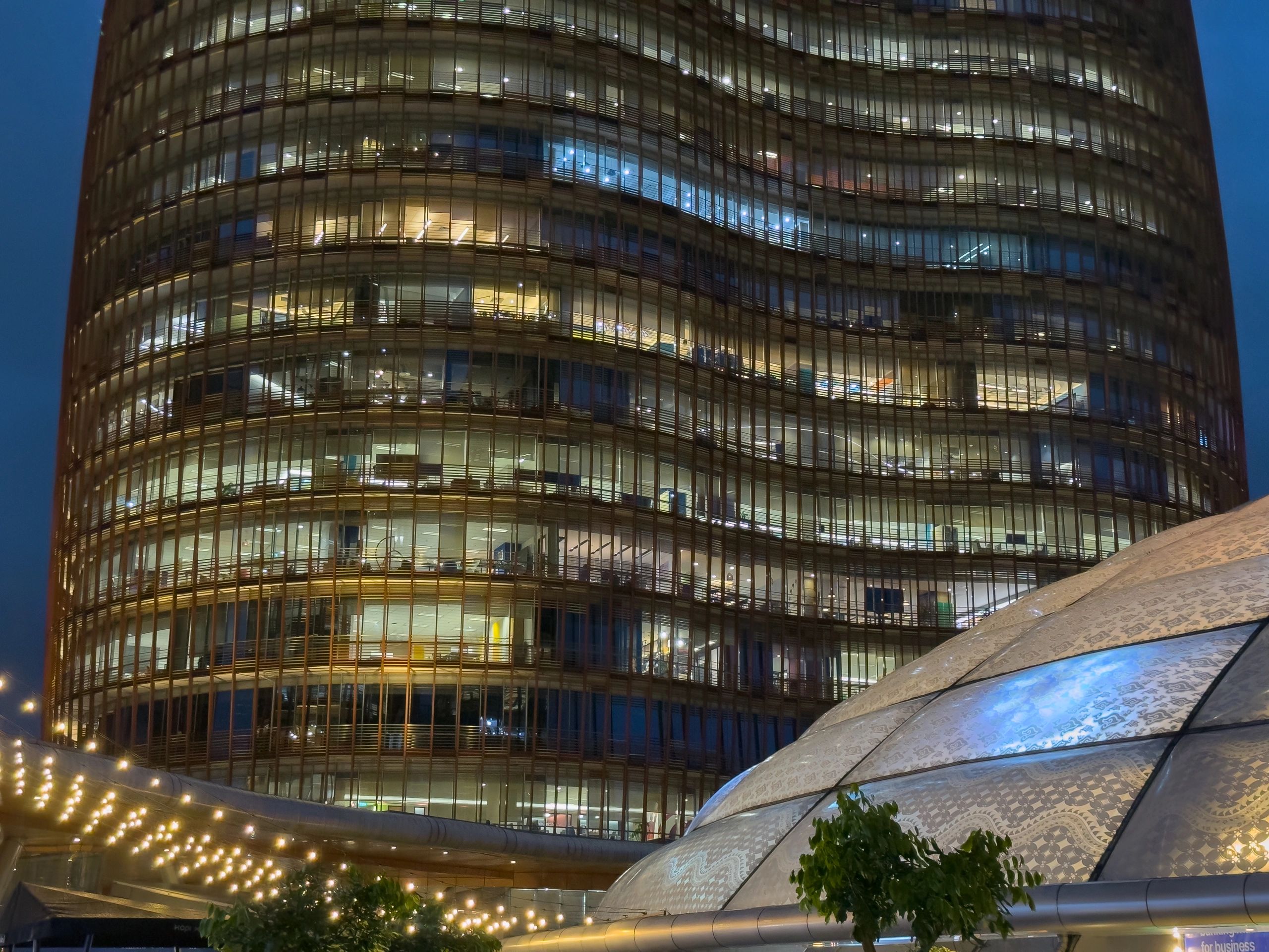 Night view of a modern glass office building with decorative lighting